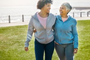 5 Most Common Health Concerns for Seniors. Adult woman and Senior woman walking and smiling.