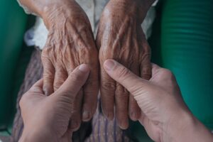 Arthritis Do's and Don'ts. Young hands hold aged hands.