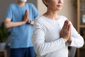 How To Help Prevent Arthritis as You Age. Older man and woman do a yoga pose.