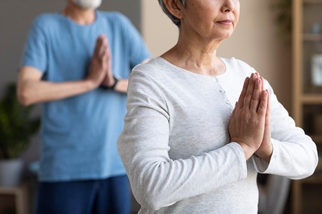 How To Help Prevent Arthritis as You Age. Older man and woman do yoga.