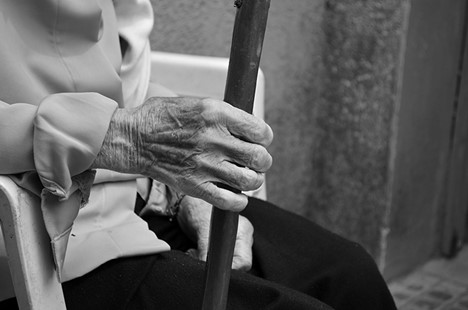 What To Do if You Suspect Elder Abuse. Black and white photo of wrinkled man's hands.