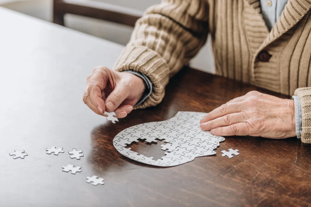 Elderly person assembling a puzzle.