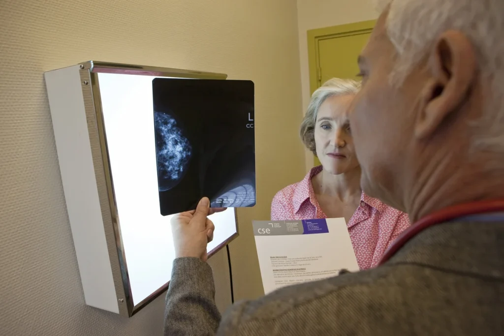 A doctor discusses a cancer prevention mammogram with a female patient in an office.