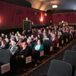group of seniors listen intently in the theatre