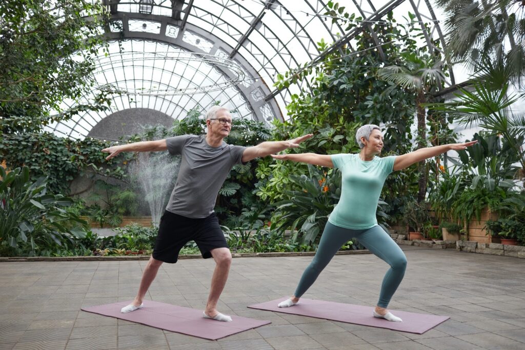 Gray haired man and woman doing yoga. Image courtesy: www.pexels.com