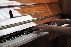 A woman enjoys the indoor activity of playing the piano